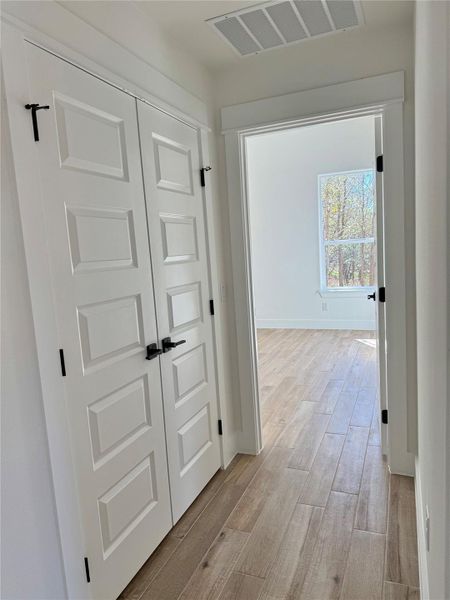 Hallway with light wood finished floors and baseboards
