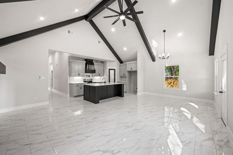 Kitchen featuring open floor plan, a chandelier, a kitchen island with sink, a ceiling fan, and extractor fan