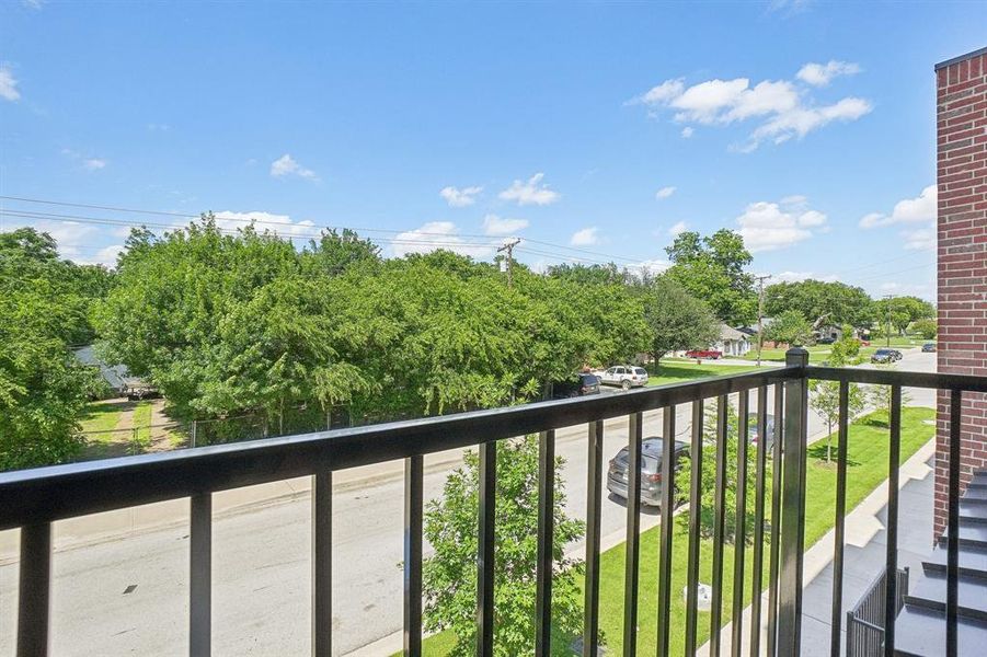 Balcony featuring view of wooded area