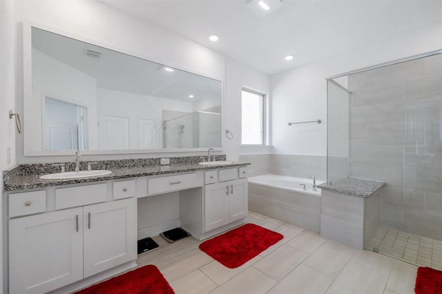 Bathroom with double vanity, a sink, a bath, and a shower stall