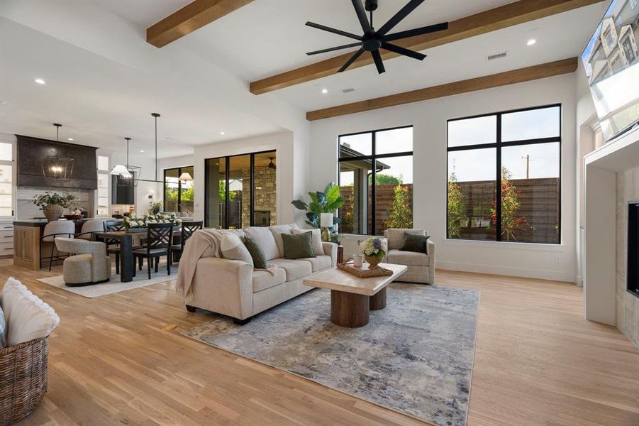 Living area with a fireplace, beamed ceiling, light wood-type flooring, recessed lighting, and ceiling fan Living area with a fireplace, beamed ceiling, light wood-type flooring, recessed lighting, and ceiling fan