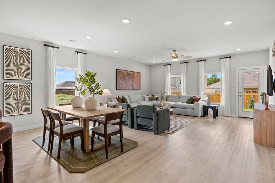 A large living room with a dining table and chairs. A large living room with a dining table and chairs.