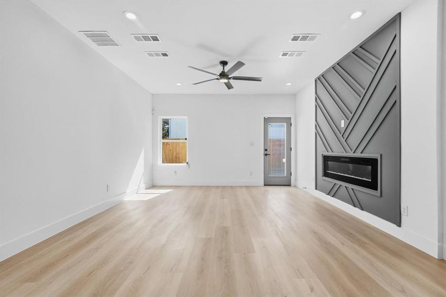 Unfurnished living room featuring light wood-style flooring, ceiling fan, and recessed lighting