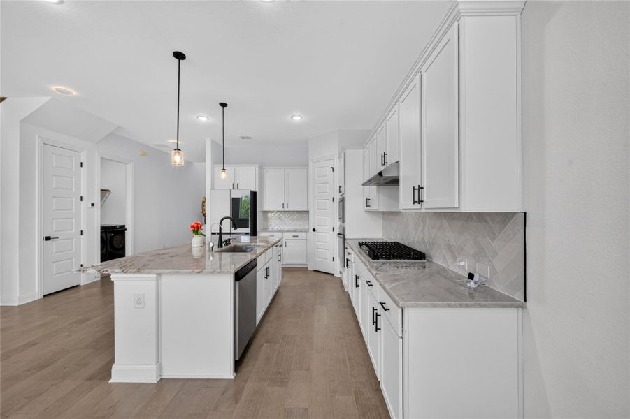 Gleaming stone countertops and classic shaker cabinetry anchor this light-filled culinary space. Gleaming stone countertops and classic shaker cabinetry anchor this light-filled culinary space.