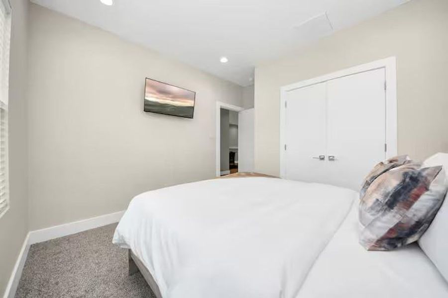 A comfortable secondary bedroom with enough space for a full bedroom setup while maintaining easy access to the nearby bath.