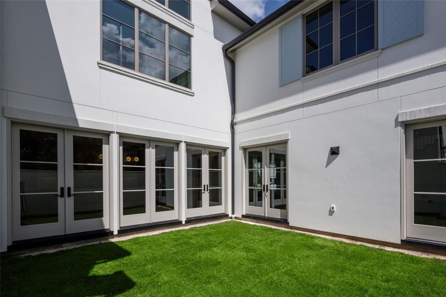 One of the home's best surprises is tucked quietly inside. Multiple sets of French doors surround a private courtyard, creating a sunny outdoor room at the center of this newly finished residence.