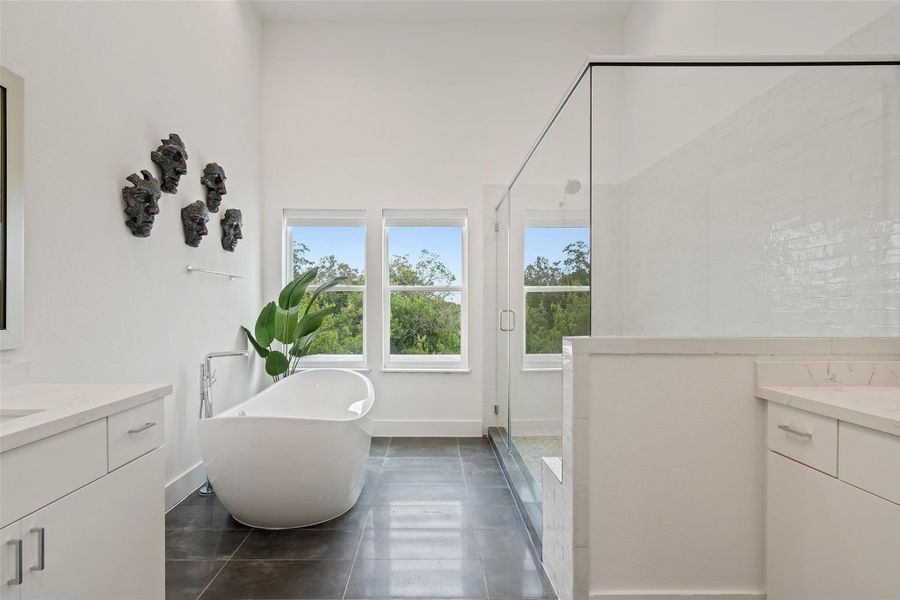 Full bath featuring vanity, a freestanding bath, a stall shower, and tile patterned floors