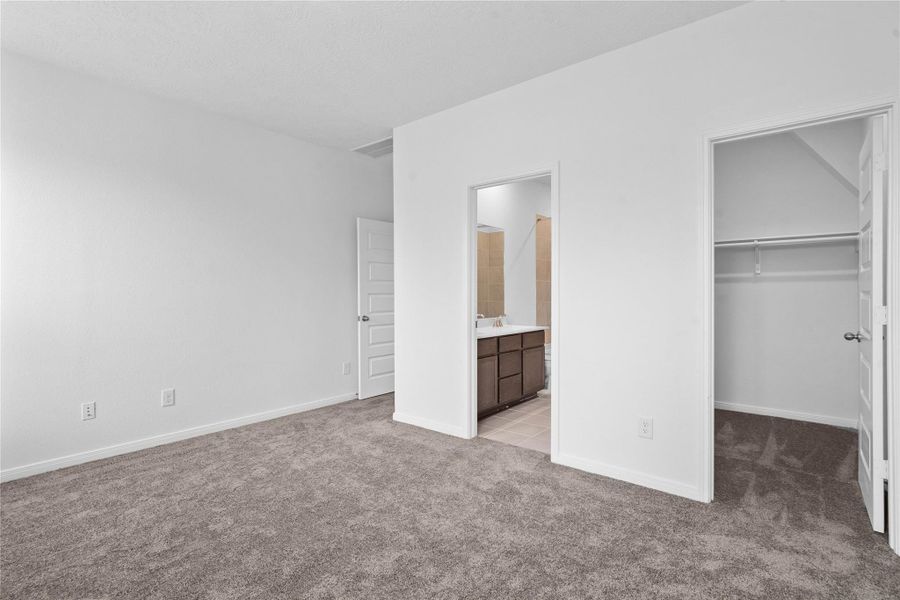 The primary suite's walk-in closet and ensuite bathroom.
