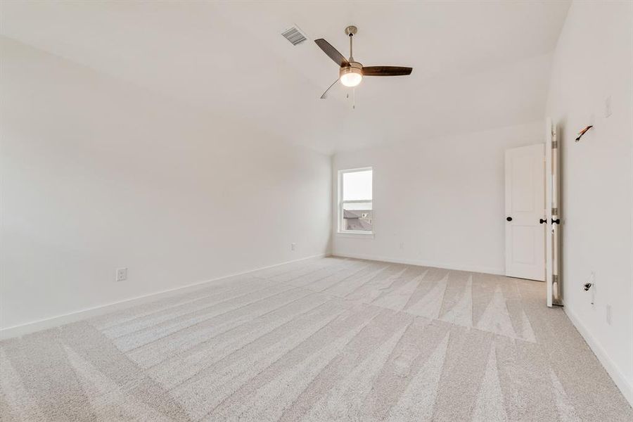 Unfurnished room with light colored carpet, a ceiling fan, and lofted ceiling Unfurnished room with light colored carpet, a ceiling fan, and lofted ceiling