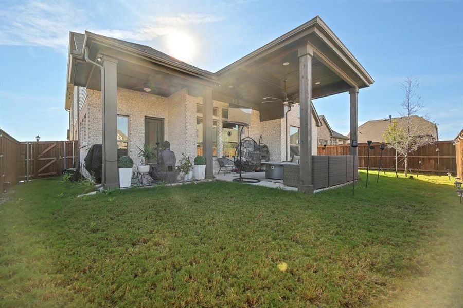 Back of property featuring a patio area, ceiling fan, a yard, and an outdoor living space