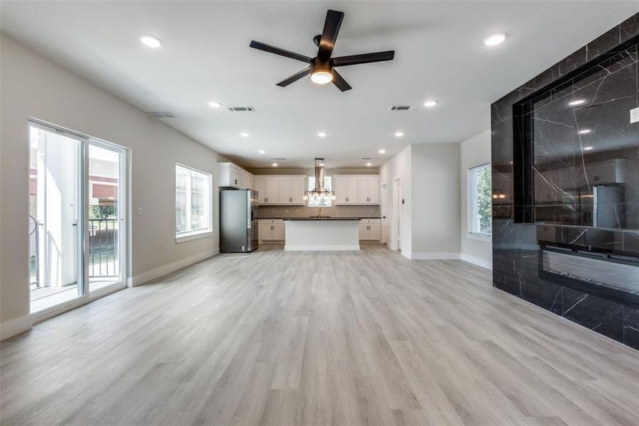 Unfurnished living room featuring a ceiling fan, light wood finished floors, and recessed lighting
