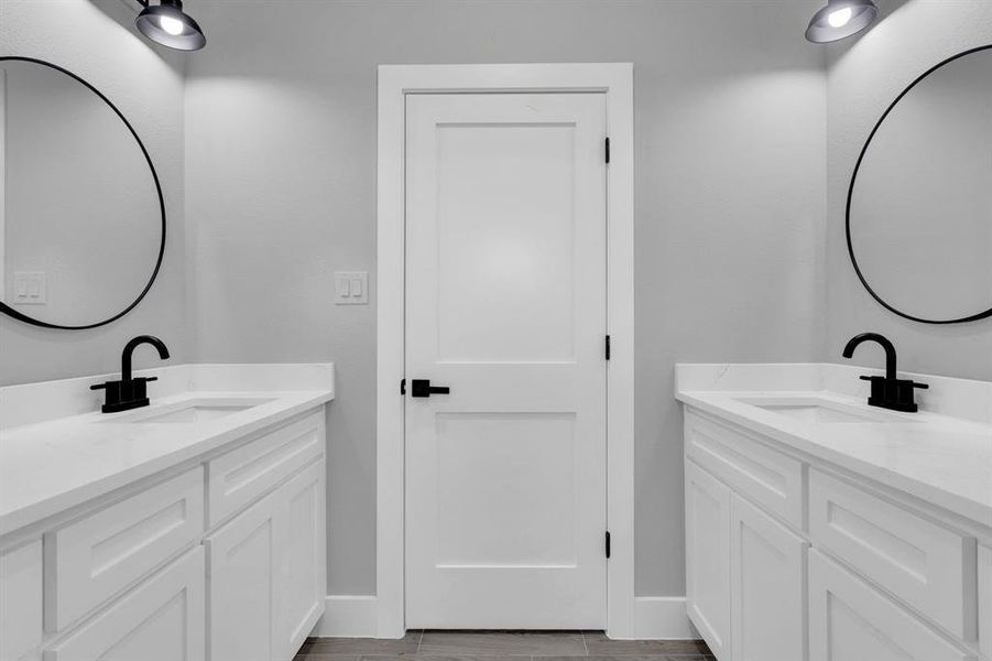 Bathroom featuring two vanities and wood tiled floors