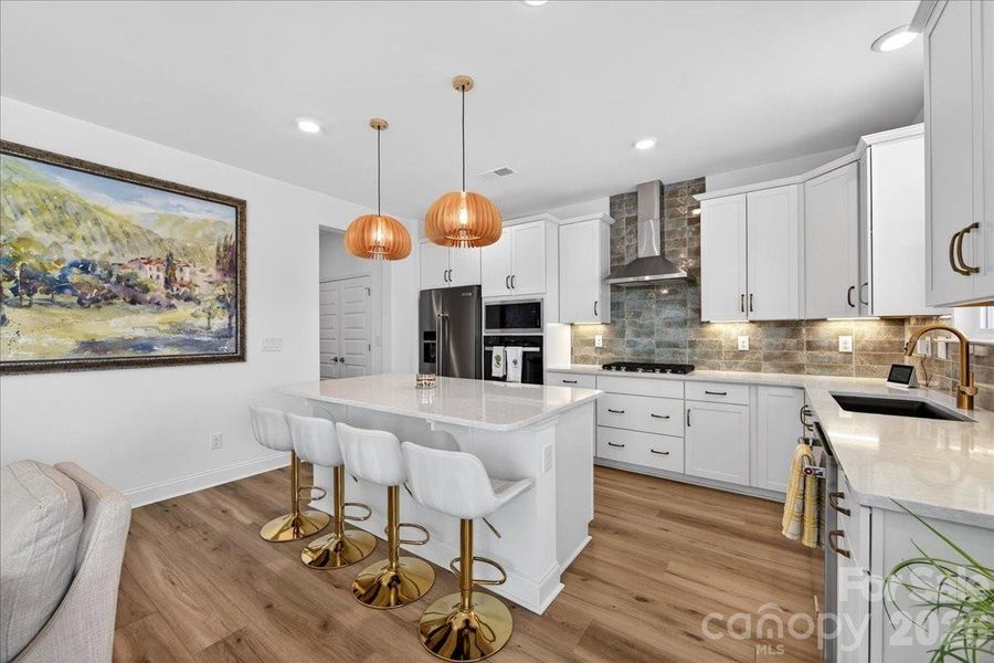 Tasteful lighting has been added above the island to bring a touch of elegance and warmth to the kitchen.