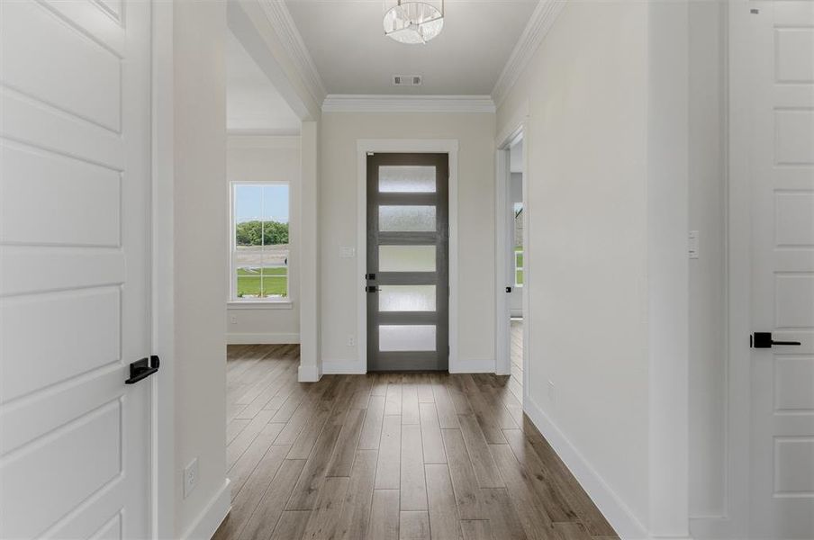 Entryway featuring wood-finish flooring, a modern glass-paneled entry door, and recessed lighting