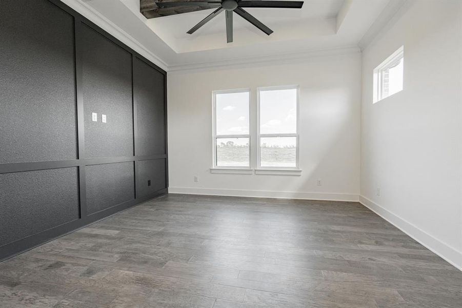 Unfurnished master bedroom featuring crown molding, hardwood / wood-style floors, and ceiling fan