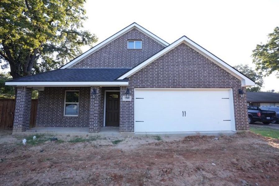View of front of home with a porch, brick siding, an attached garage, and driveway View of front of home with a porch, brick siding, an attached garage, and driveway