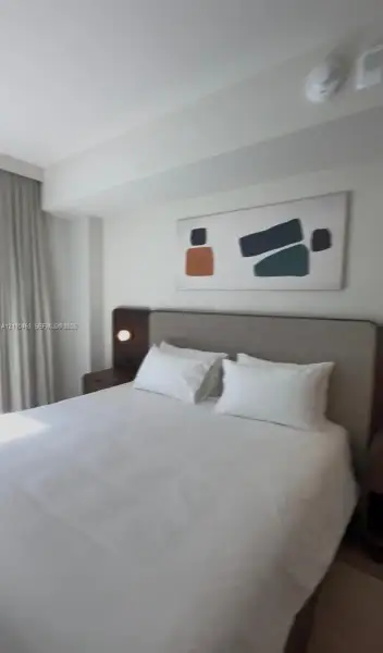 Custom upholstered headboard with integrated bedside shelving and circular wall-mounted lighting