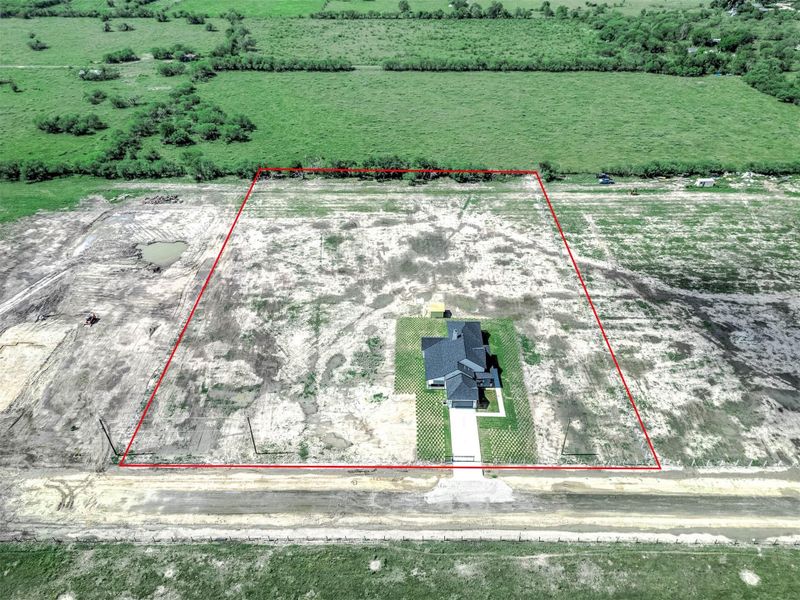Aerial view showing the property boundaries and the full lot surrounding the home.