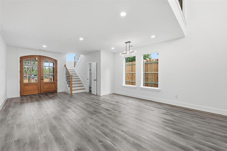 Entryway featuring stairway, french doors, wood finished floors, and recessed lighting