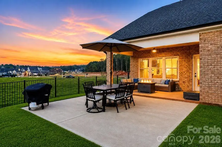 Covered patio just off the kitchen and main living area with ceiling fan and comfortable seating, ideal for relaxing or enjoying outdoor gatherings.