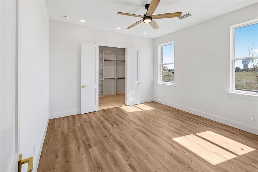 Unfurnished bedroom with a closet, light wood-type flooring, and ceiling fan