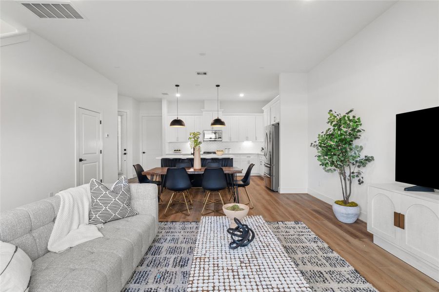 The airy layout is enhanced by high ceilings and strategically placed recessed lighting, creating a bright and inviting atmosphere.