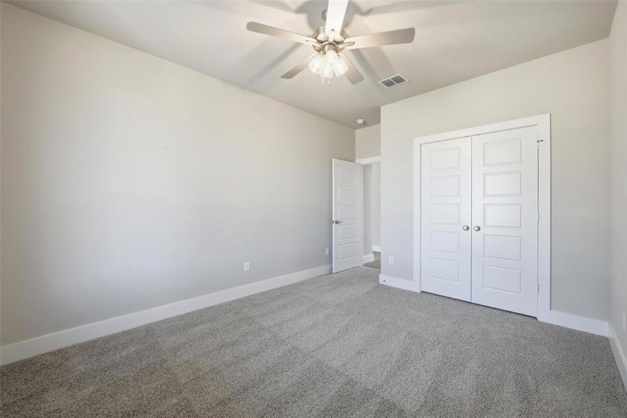 Unfurnished bedroom with carpet, ceiling fan, and a closet