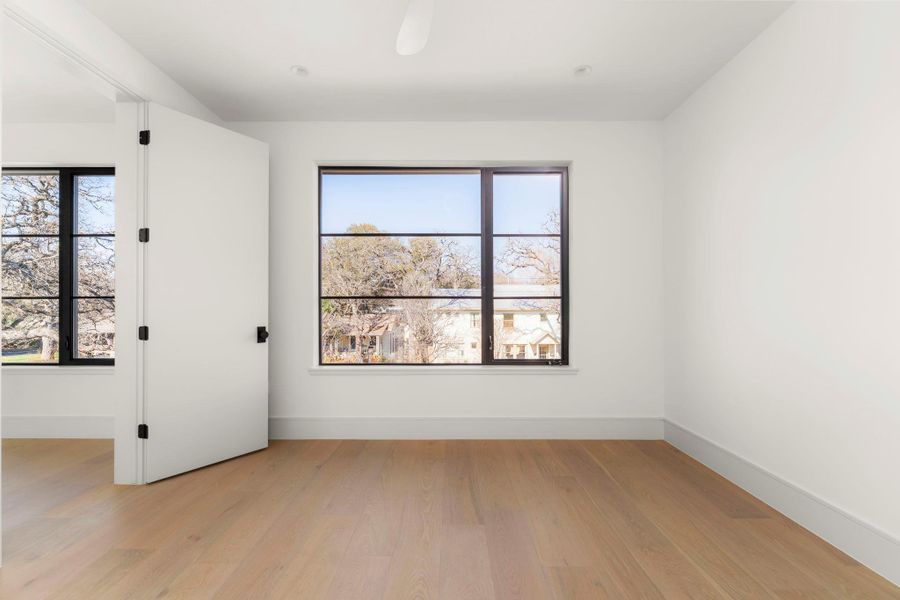 Empty room with light wood-style floors and plenty of natural light