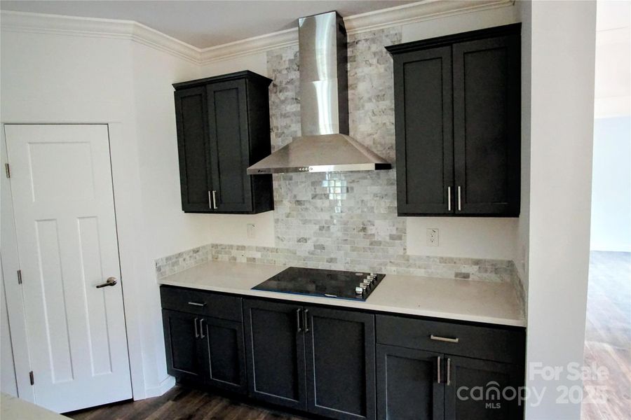 Cooktop with exhaust hood and tiled backsplash Cooktop with exhaust hood and tiled backsplash