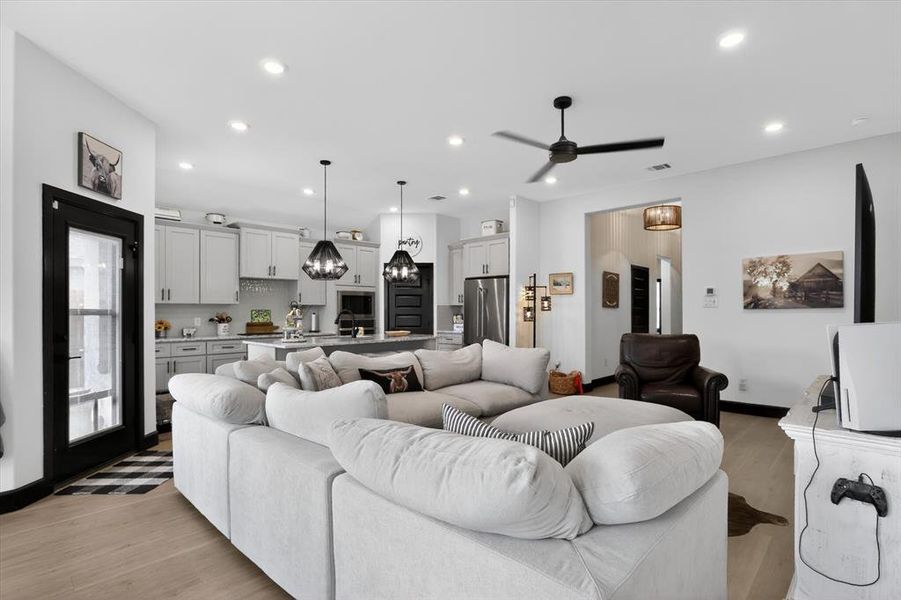 Open-concept living space featuring wood-finish flooring, recessed lighting, and a modern ceiling fan
