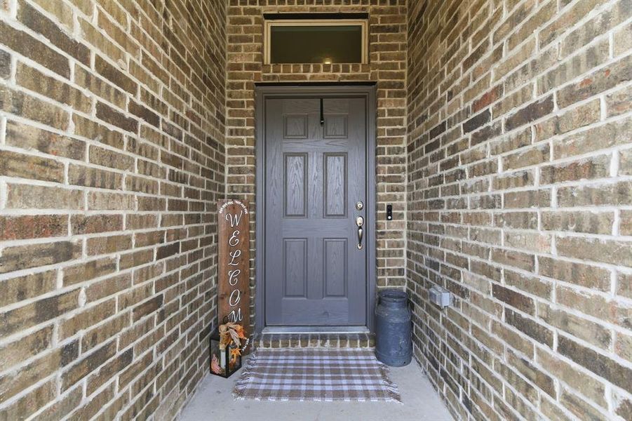 View of exterior entry featuring brick siding