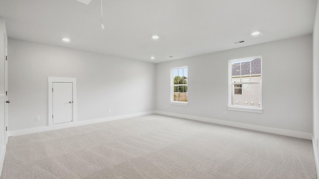 Elegant, carpeted loft that adds a superior layer of flexibility to the home’s design at Woodglen