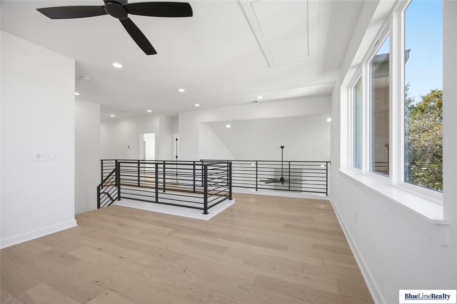 Corridor featuring an upstairs landing, light wood finished floors, and recessed lighting