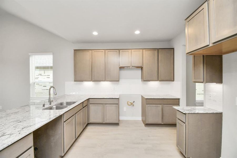 This kitchen is by far any chef’s dream! This spacious kitchen features high ceilings, dark stained wood cabinets, granite countertop, SS appliances (To be Installed), modern tile backsplash, recessed lighting, extended counter space and all overlooking your huge family room. Example photo of completed home with similar plan. Actual may vary.