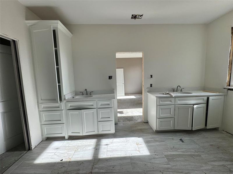 Kitchen featuring kitchen peninsula, sink, and white cabinets