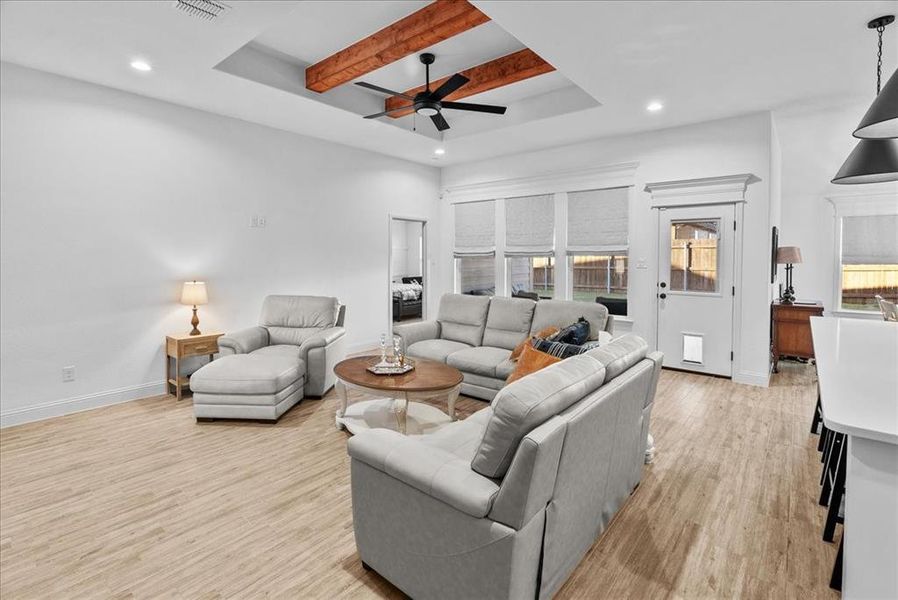 Living room featuring beam ceiling, recessed lighting, light wood finished floors, baseboards, and ceiling fan