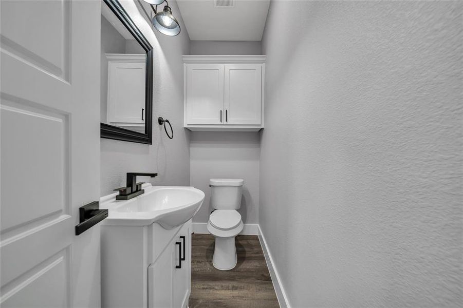 Bathroom featuring vanity, hardwood / wood-style flooring, and toilet