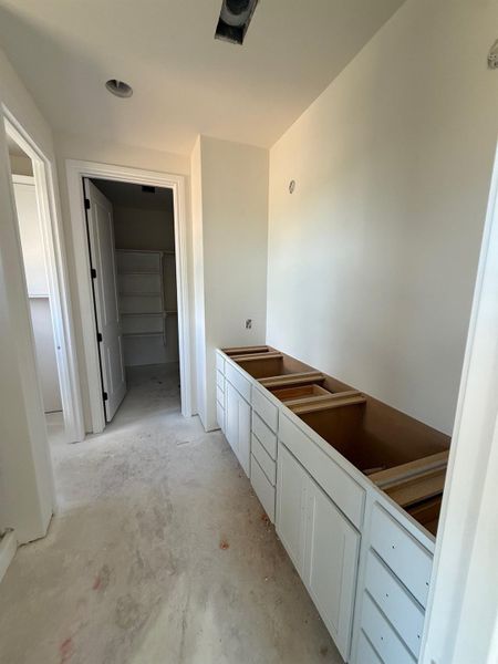 Full bath with unfinished concrete flooring, a spacious closet, and vanity