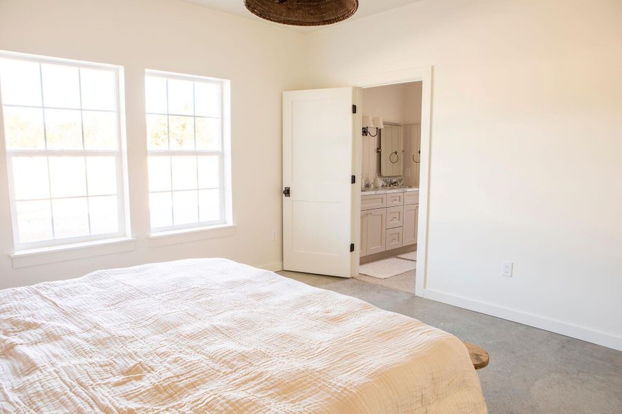 Bedroom featuring baseboards and ensuite bath Bedroom featuring baseboards and ensuite bath