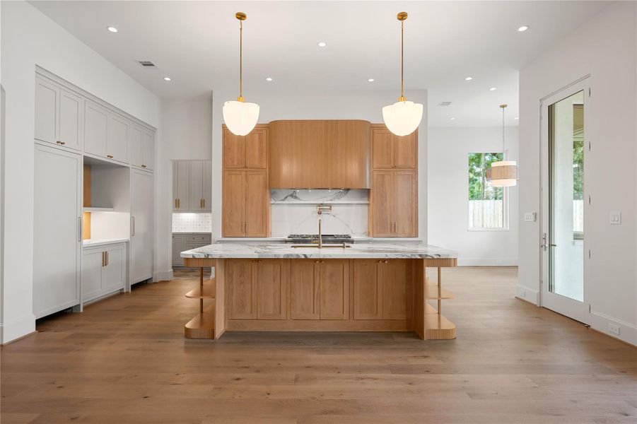 The kitchen island features two cloverlike lights, hand-blown from etched opal glass.