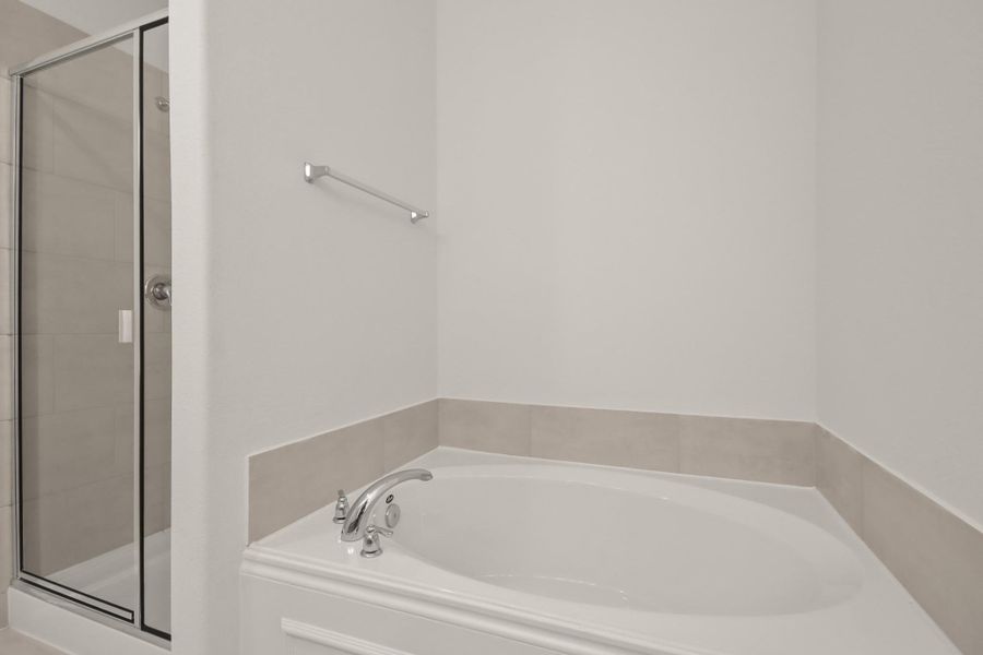 This additional view of your primary bathroom features tile flooring, fresh paint, walk-in shower, a separate garden tub, and a large walk-in closet. This additional view of your primary bathroom features tile flooring, fresh paint, walk-in shower, a separate garden tub, and a large walk-in closet.