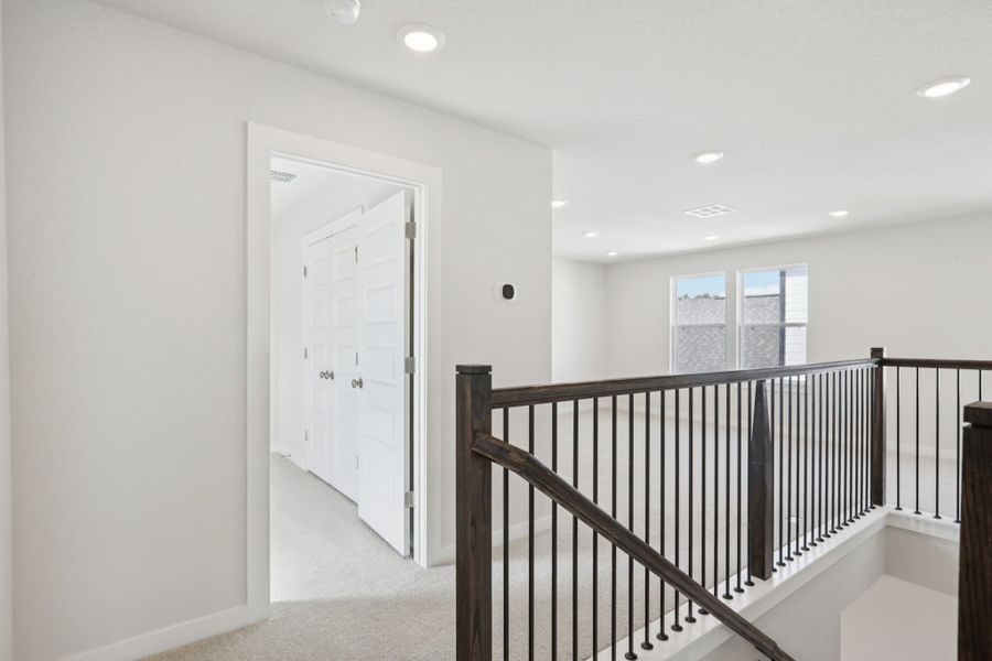 A white room with a black railing.