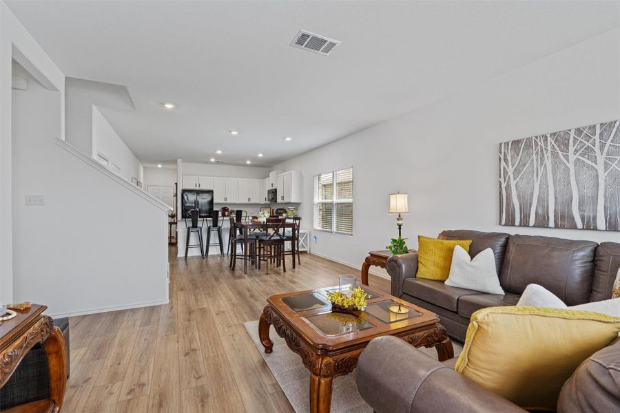 Living room with light wood finished floors and recessed lighting