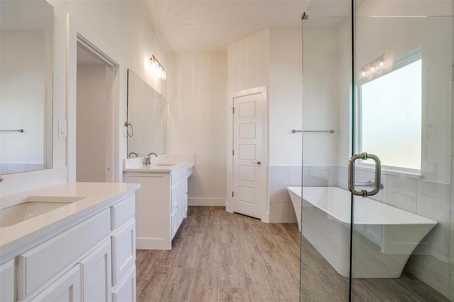 Bathroom with vanity, wood-type flooring, a washtub, and tile walls