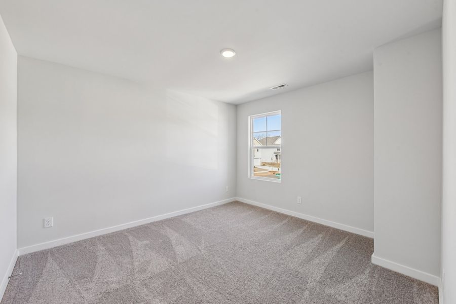 A room with a window and a carpet.