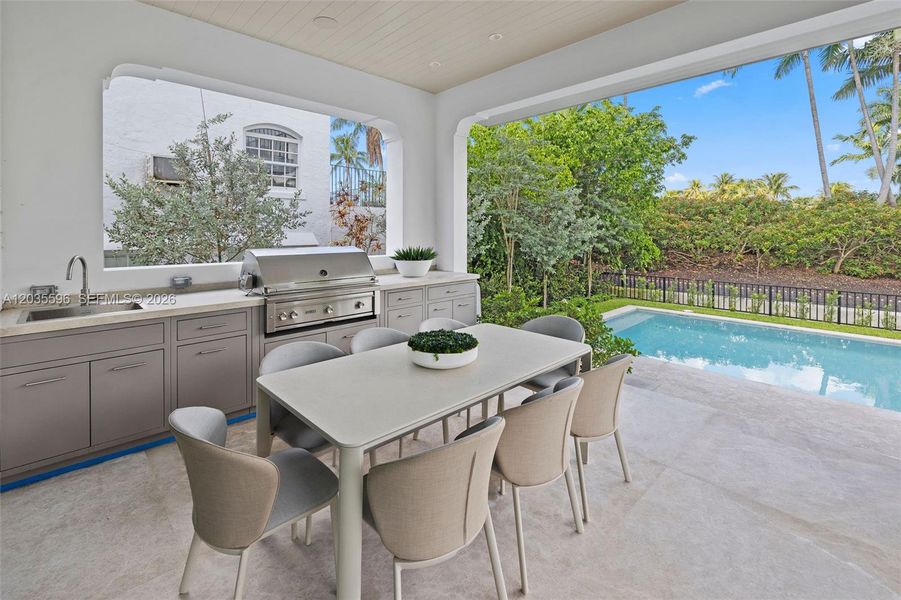 Outside living room with kitchen overlooks pool Outside living room with kitchen overlooks pool