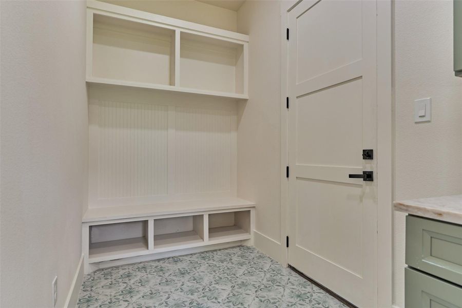 Built-in mudroom drop zone with bench seating, cubby storage, and patterned cement-tile floors — the perfect catch-all coming in from 1.5 acres. Built-in mudroom drop zone with bench seating, cubby storage, and patterned cement-tile floors — the perfect catch-all coming in from 1.5 acres.