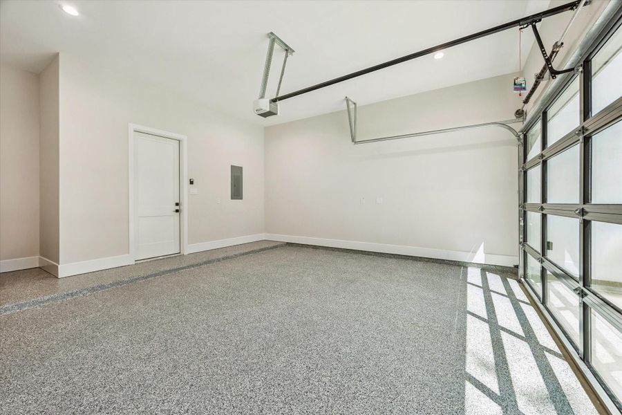 The garage is finished with a durable epoxy floor that combines style with easy maintenance. A modern glass-and-metal door elevates curb appeal, while abundant storage and EV-charger wiring ensure the space is ready for the future.