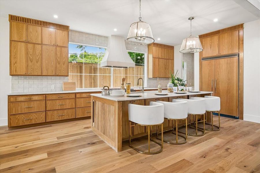 Custom oak cabinetry, Taj Mahal leathered quartzite island with bar seating, panel-ready refrigerator Custom oak cabinetry, Taj Mahal leathered quartzite island with bar seating, panel-ready refrigerator