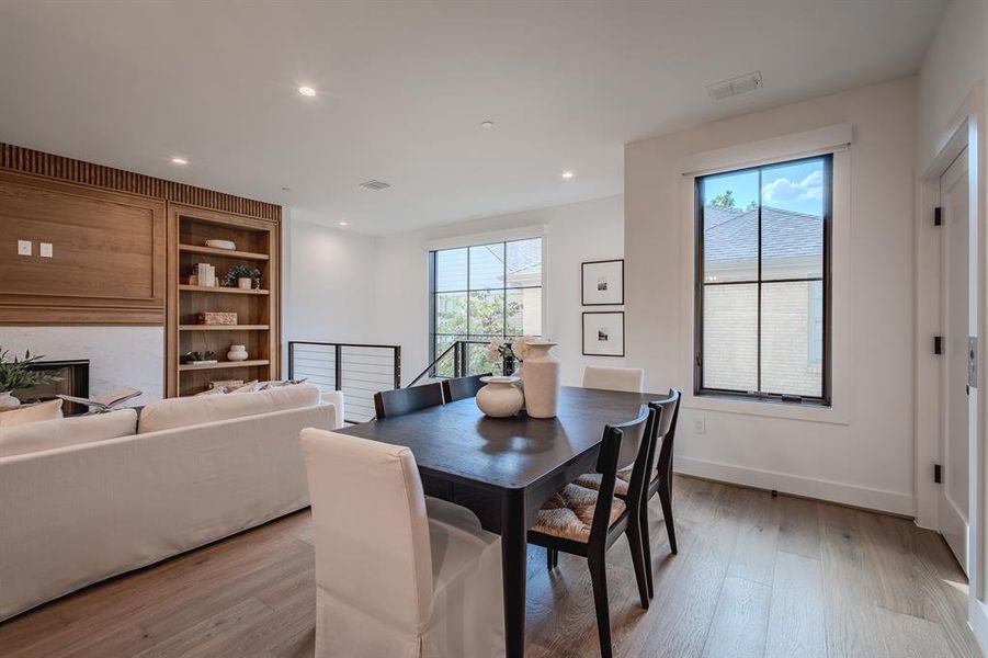 Dining area featuring plenty of natural light, light wood-type flooring, recessed lighting, and a glass covered fireplace Dining area featuring plenty of natural light, light wood-type flooring, recessed lighting, and a glass covered fireplace